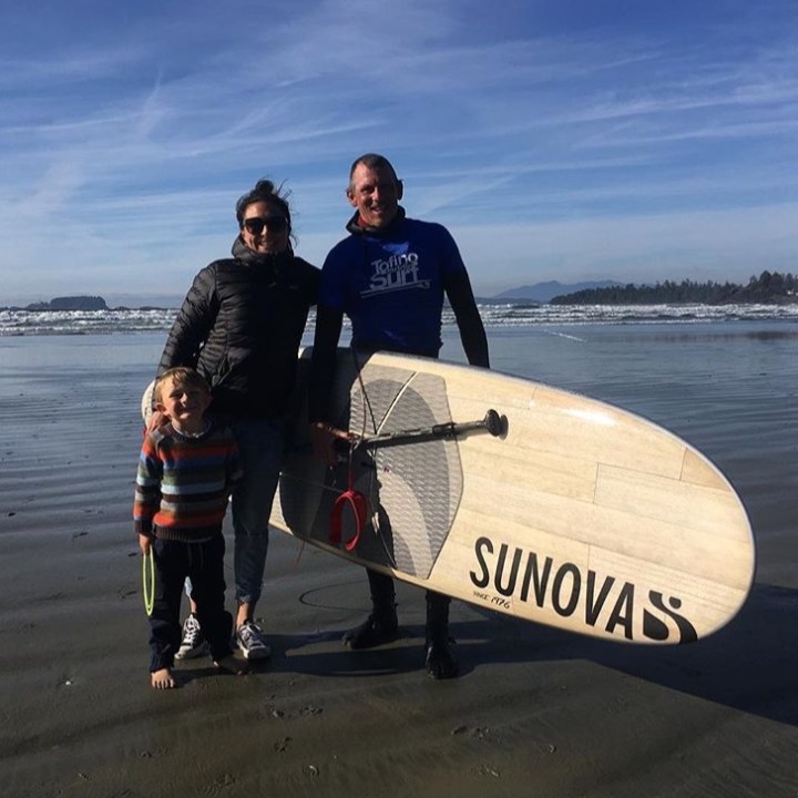 a man carrying a surf board on a body of water