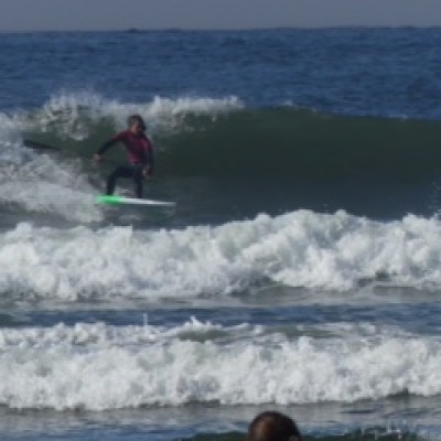 a man and a woman riding a wave on a surfboard in the ocean