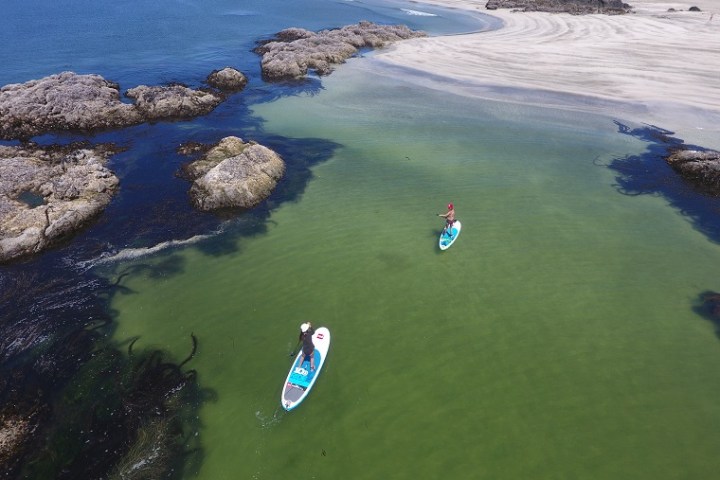 a group of people on a beach near a body of water
