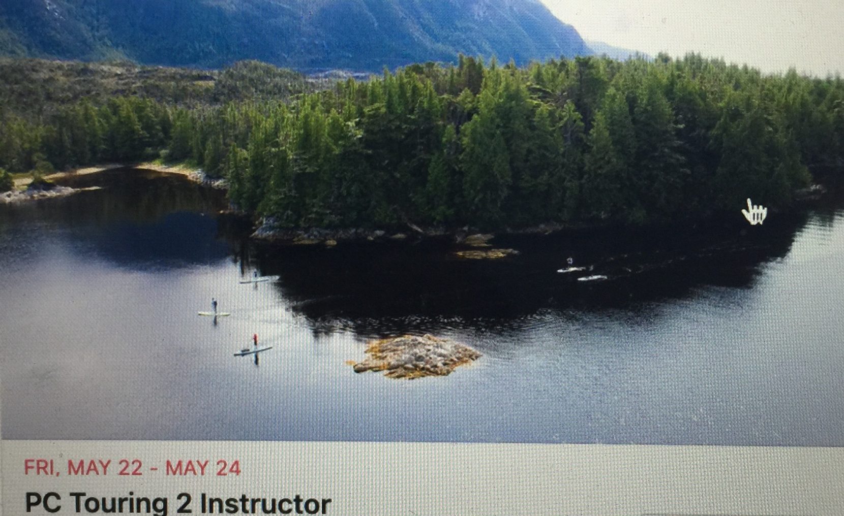 a small boat in a body of water with a mountain in the background