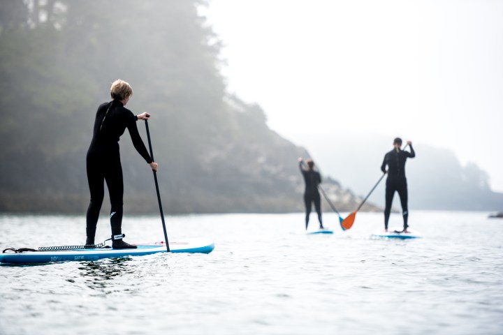 Three paddle boarders paddling on the lake