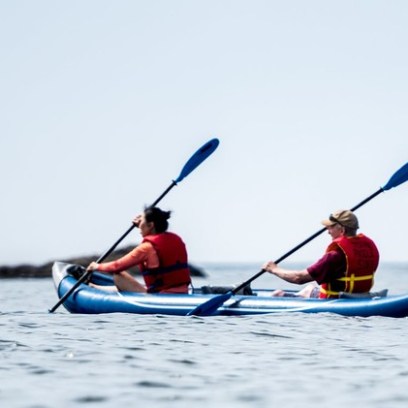 a group of people rowing a boat in a body of water