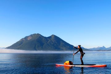 a man riding on the back of a boat in a body of water