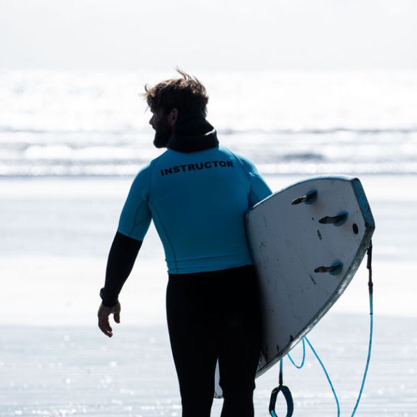 a man carrying a surf board on a body of water