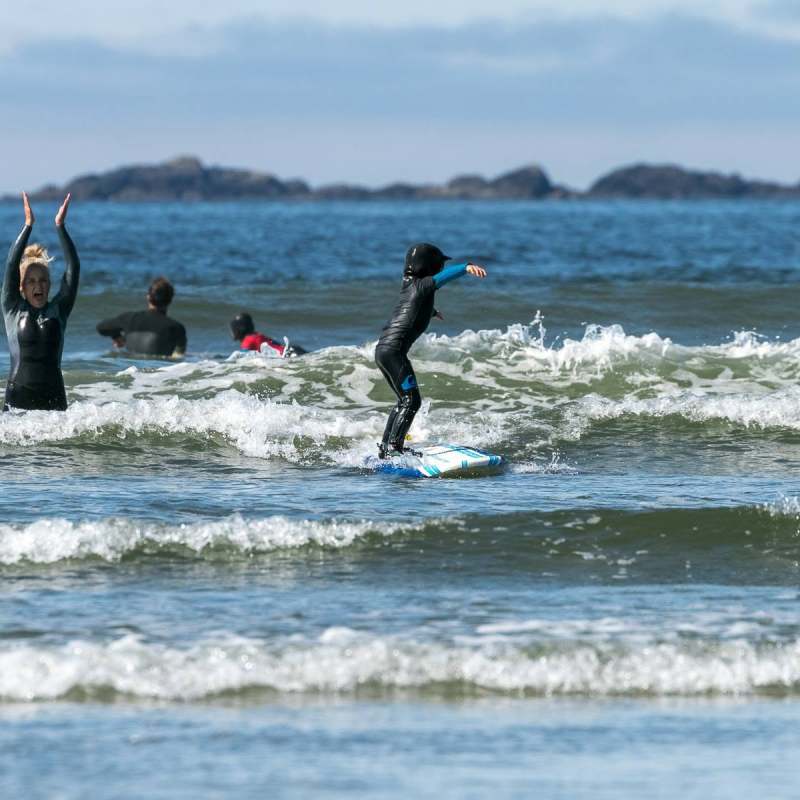 People surfing and playing in the ocean waves on a sunny day.
