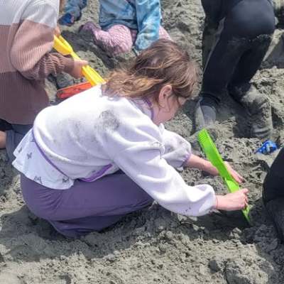 Children playing in sand with shovels and toys.